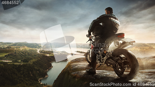 Image of Biiker on highway, riding around a curve with a motion blur toned