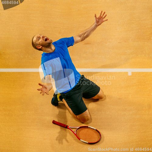 Image of Portrait of a handsome male tennis player celebrating his success at court