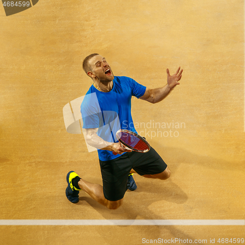 Image of Portrait of a handsome male tennis player celebrating his success at court