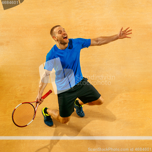 Image of Portrait of a handsome male tennis player celebrating his success at court