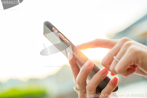 Image of Sending sms on cellphone at outdoor