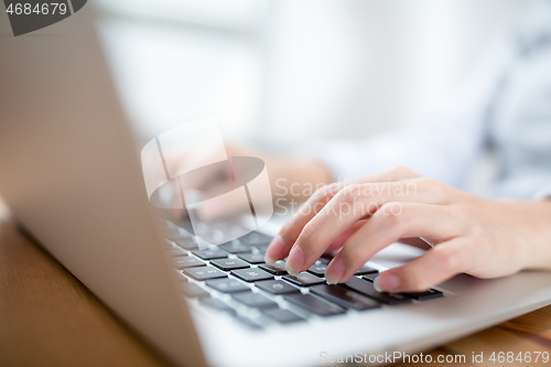 Image of Woman hand typing on laptop keyboard