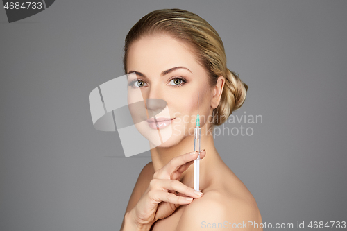 Image of beautiful girl holding syringe