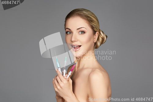 Image of beautiful girl holding syringes