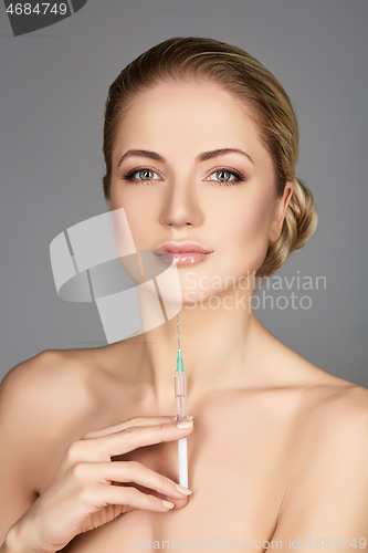 Image of beautiful girl holding syringe