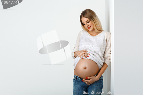 Image of Beautiful pregnant woman in jeans