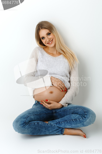 Image of Beautiful pregnant woman in jeans