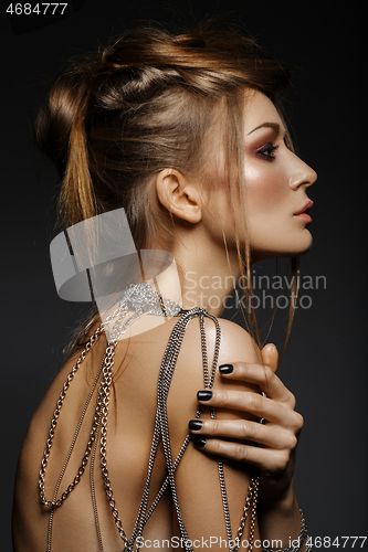 Image of beautiful girl with many golden and bronze chains