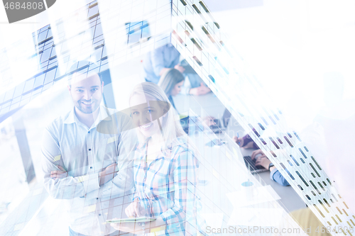 Image of Two Business People Working With Tablet in office