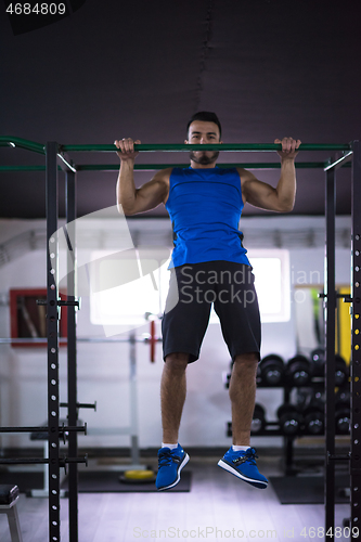 Image of man doing pull ups on the horizontal bar