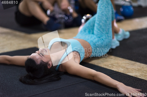 Image of young athlete woman lying on the floor and relaxing