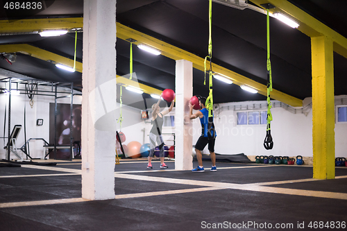 Image of young athletes couple working out with medical ball