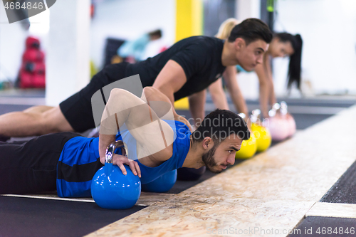 Image of young athletes doing pushups with kettlebells