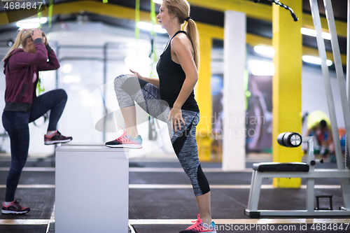 Image of athletes working out  jumping on fit box