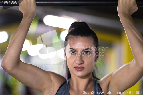 Image of woman doing pull ups on the horizontal bar