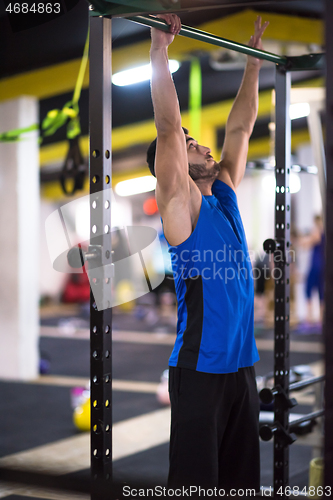 Image of man doing pull ups on the horizontal bar