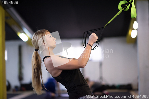 Image of woman working out pull ups with gymnastic rings