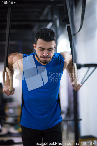 Image of man working out pull ups with gymnastic rings