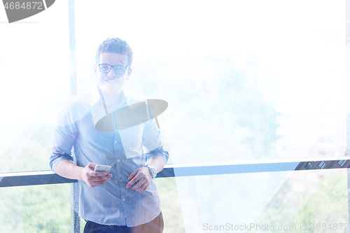 Image of Businessman Standing In A Modern Building Near The Window With P