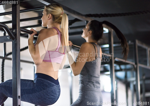 Image of young athletes doing pull ups on the horizontal bar