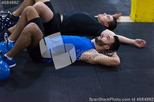 Image of young athletes lying on the floor and relaxing