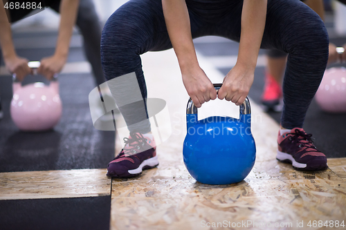 Image of athletes doing exercises with kettlebells