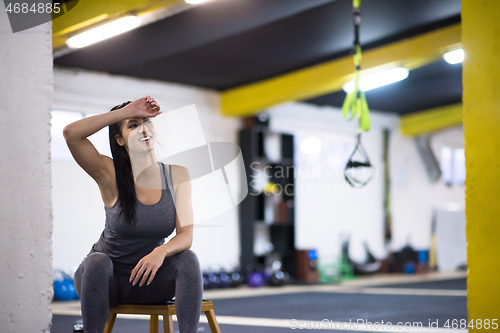 Image of young athlete woman sitting and relaxing