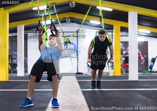 Image of men working out pull ups with gymnastic rings