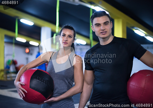 Image of young athletes couple working out with medical ball