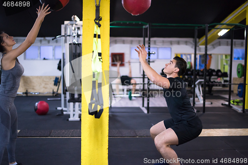 Image of young athletes couple working out with medical ball