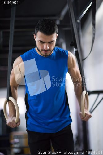 Image of man working out pull ups with gymnastic rings