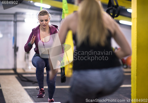 Image of athletes working out  jumping on fit box