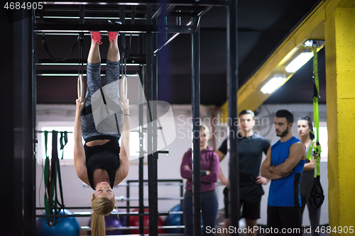 Image of woman working out with personal trainer on gymnastic rings