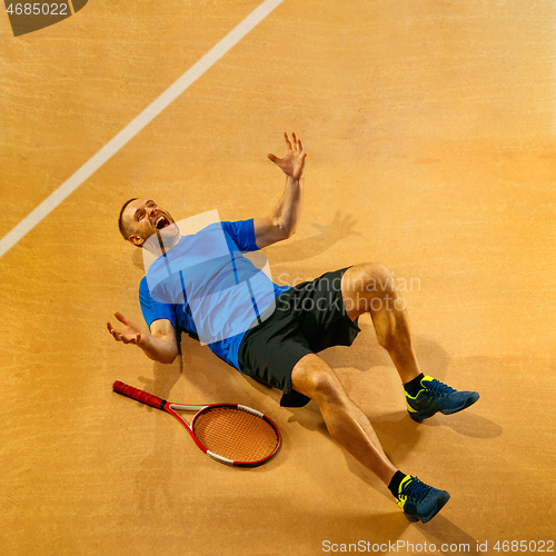 Image of Portrait of a handsome male tennis player celebrating his success at court