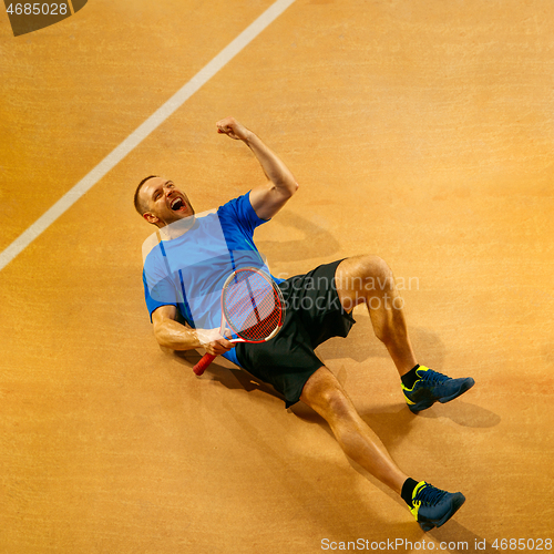 Image of Portrait of a handsome male tennis player celebrating his success at court