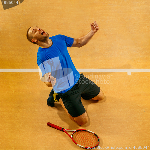 Image of Portrait of a handsome male tennis player celebrating his success at court