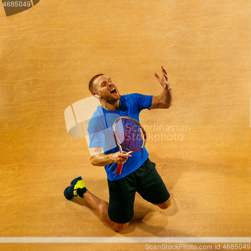 Image of Portrait of a handsome male tennis player celebrating his success at court