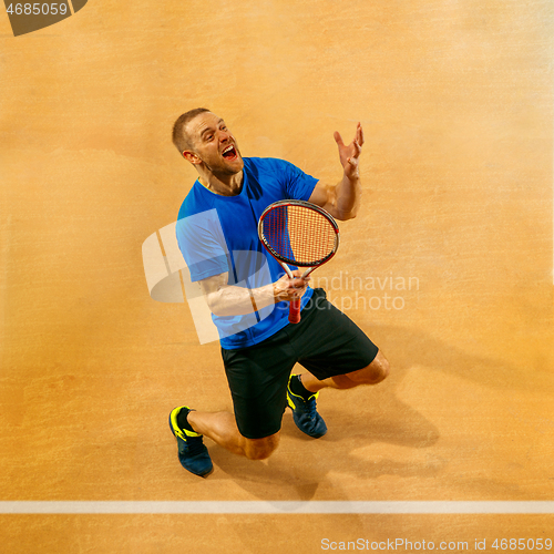 Image of Portrait of a handsome male tennis player celebrating his success at court