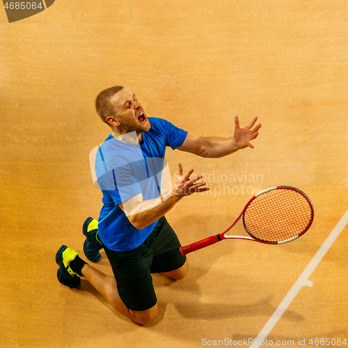 Image of Portrait of a handsome male tennis player celebrating his success at court