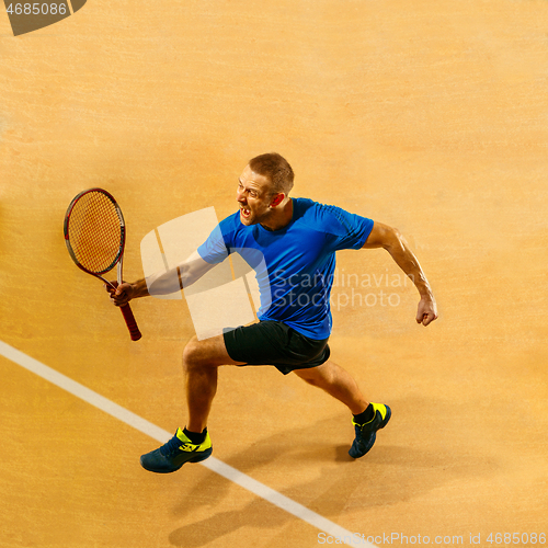 Image of Portrait of a handsome male tennis player celebrating his success at court