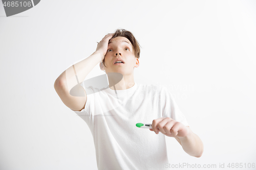 Image of Upset man looking in pregnancy test. Frustrated model