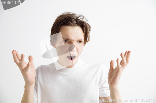 Image of The young attractive man looking suprised isolated on gray