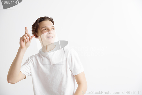 Image of The happy student standing and smiling against gray background.