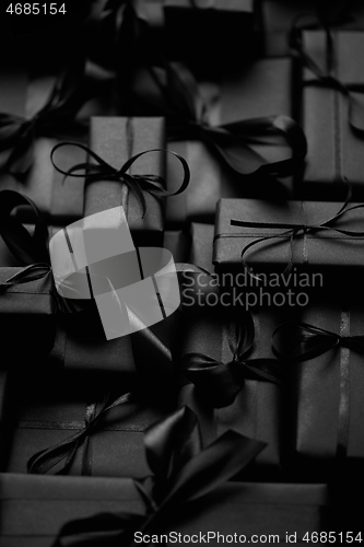 Image of A pile various size black boxed gifts placed on stack. Christmas concept.