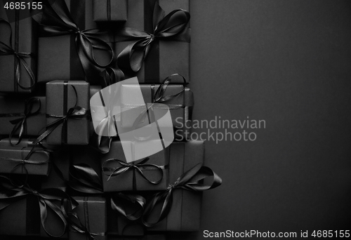 Image of A pile various size black boxed gifts placed on stack. Christmas concept.