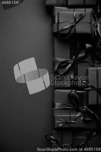 Image of A pile various size black boxed gifts placed on stack. Christmas concept.