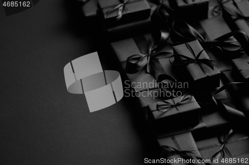 Image of A pile various size black boxed gifts placed on stack. Christmas concept.