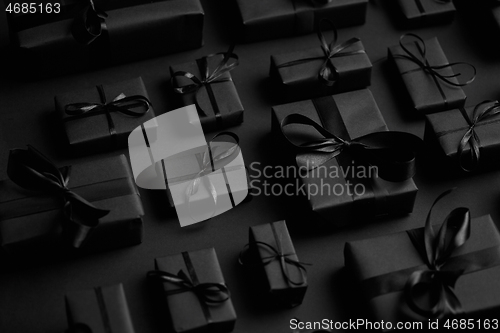 Image of Elegant black Christmas theme. Wrapped gifts in black matte paper with ribbon