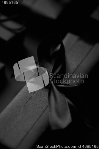 Image of Black Christmas concept. Close up on elegant black matte wrapped gifts with ribbon.