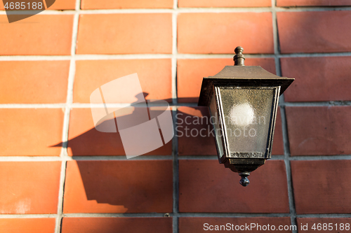 Image of Street lamp on brick wall